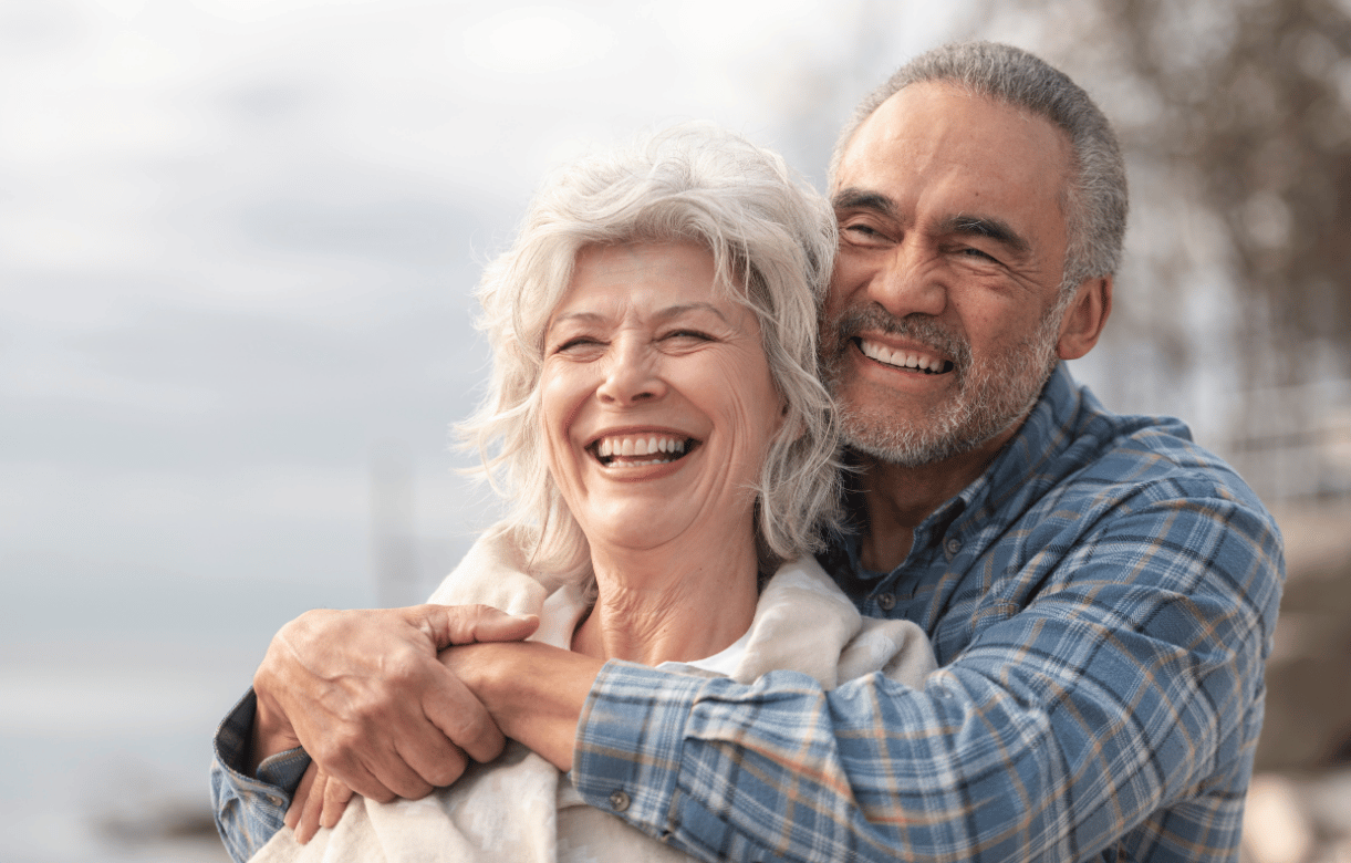 Smiling senior couple embracing outdoors